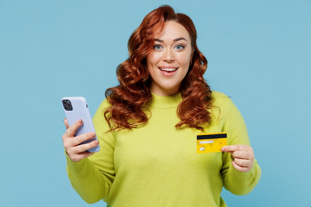 Young Woman Smiling Holding Credit Card and Phone